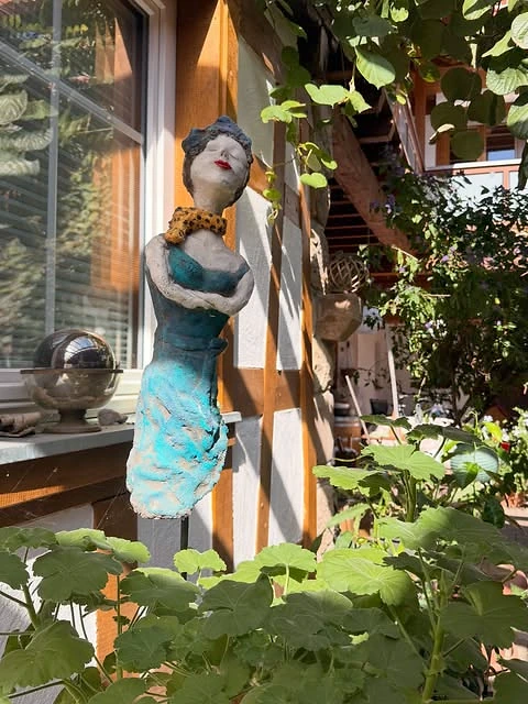 Dekorative Figur zwischen Pflanzen am Gästehaus